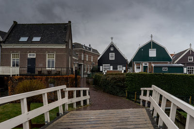 Footpath amidst buildings against sky