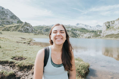 Portrait of young woman standing against mountain