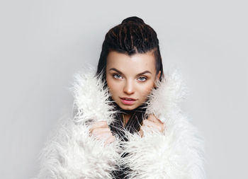 Portrait of young woman against white background