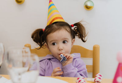 Portrait of a beautiful girl blowing a trumpet at a birthday party.