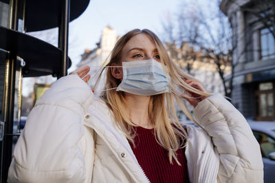 Portrait of young woman standing in winter with mask 