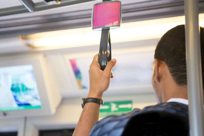 Rear view of man photographing through window