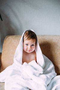 Cute child with blue eyes wrapped in a white towel.