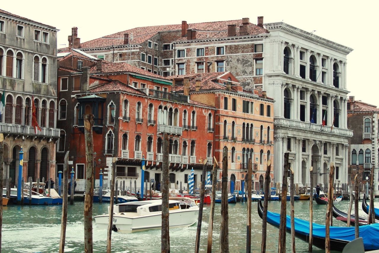 nautical vessel, building exterior, architecture, water, built structure, boat, transportation, mode of transport, moored, waterfront, canal, clear sky, incidental people, city, building, day, travel, residential building, sky, outdoors