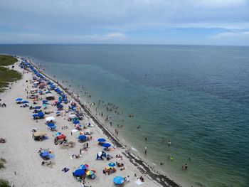 Aerial view of people at beach against sky