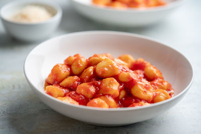 Gnocchi with tomato sauce and parmigiano on a plate.