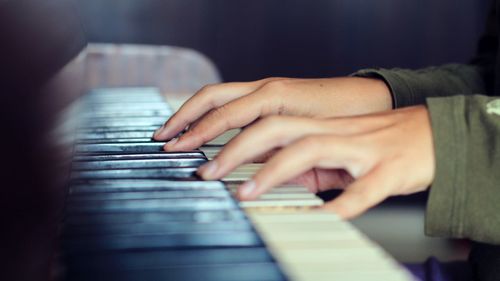 Cropped hands playing piano