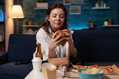 Portrait of young woman using mobile phone while sitting on table