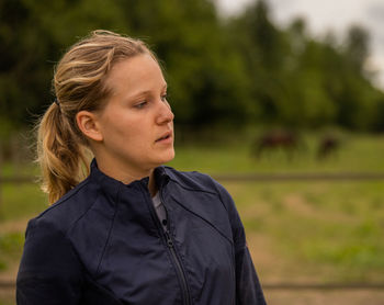 Portrait of young woman looking away in countryside