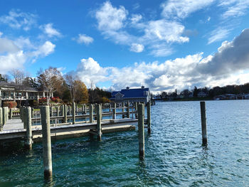 Wooden post in swimming pool by sea against sky