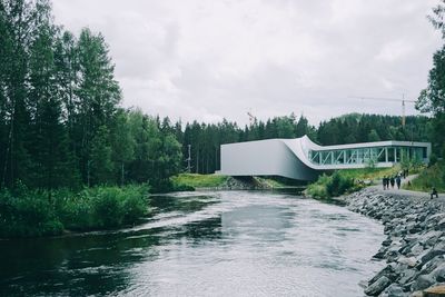 Scenic view of river amidst trees against sky