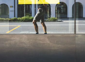 Low section of man standing on road