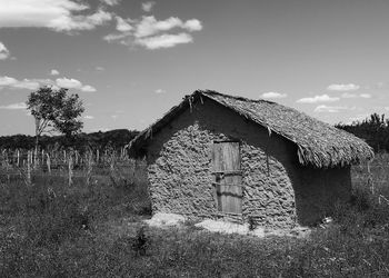 Abandoned house on field against sky