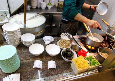 Midsection of man preparing food in kitchen at restaurant