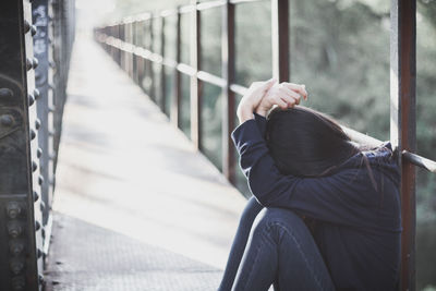 Sad woman sitting on bridge