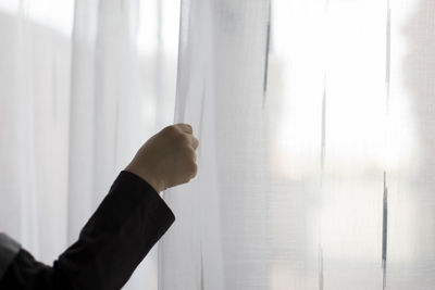 Close-up of man hand holding window