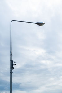 Low angle view of bird perching on street light