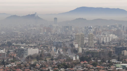 Aerial view of buildings in city against sky