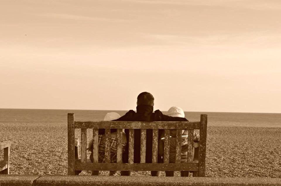 VIEW OF PEOPLE SITTING ON BENCH