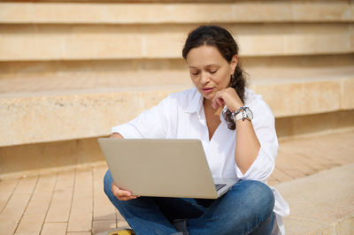 Young woman using laptop while sitting at home