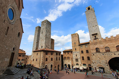 Tourists at town square against sky