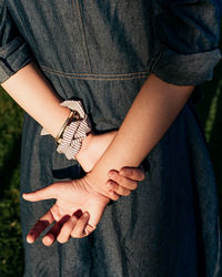 Midsection of woman with hands behind back