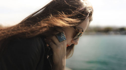 Portrait of woman wearing sunglasses against sky