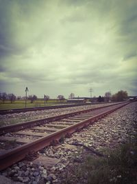 Railroad tracks on field against sky