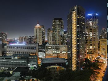 Illuminated buildings in city against sky at night