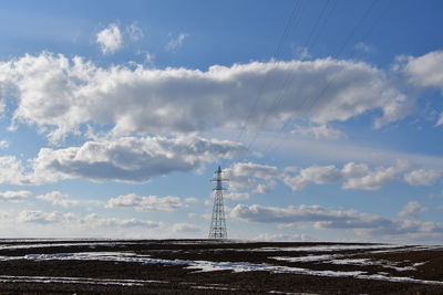 Electricity pylon on land against sky