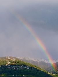 Rainbow over landscape against sky