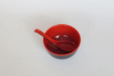 High angle view of red wine on table against white background