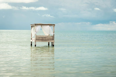 Lifeguard hut in sea against sky