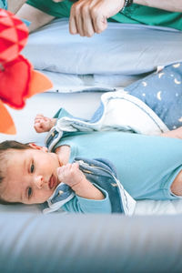 Portrait of baby lying on bed