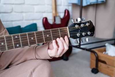 Midsection of man playing guitar