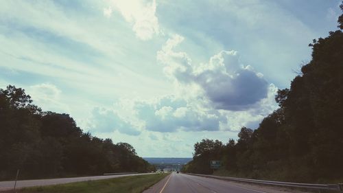 Road amidst trees against sky