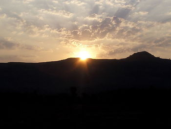 Scenic view of silhouette mountains against sky at sunset