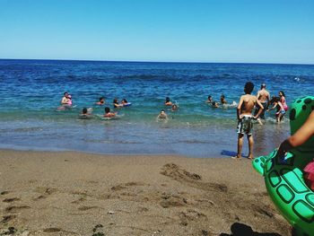 People at beach against sky