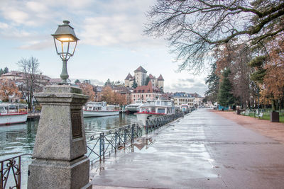 Street by river and buildings against sky