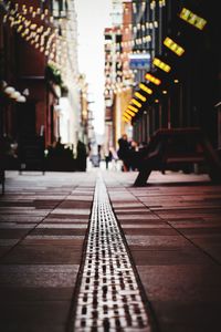 Man walking on footpath amidst buildings in city