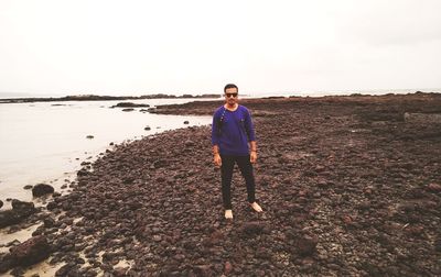 Full length of young man standing on beach