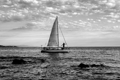 Sailboat sailing on sea against sky