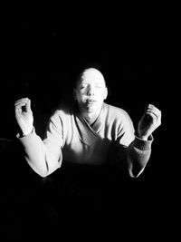 Portrait of man holding camera over black background