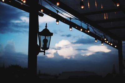 Low angle view of illuminated light against sky at sunset