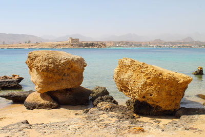 Rocks on beach against sky