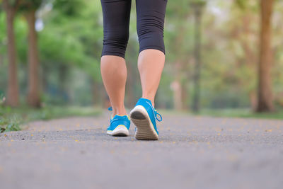 Rear view of woman walking on road