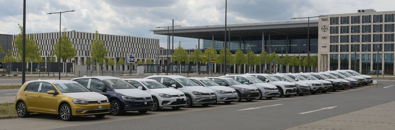 Row of cars on city street against buildings