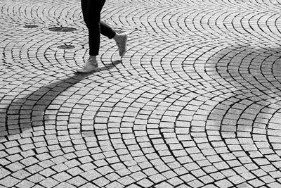 Low section of woman walking on footpath