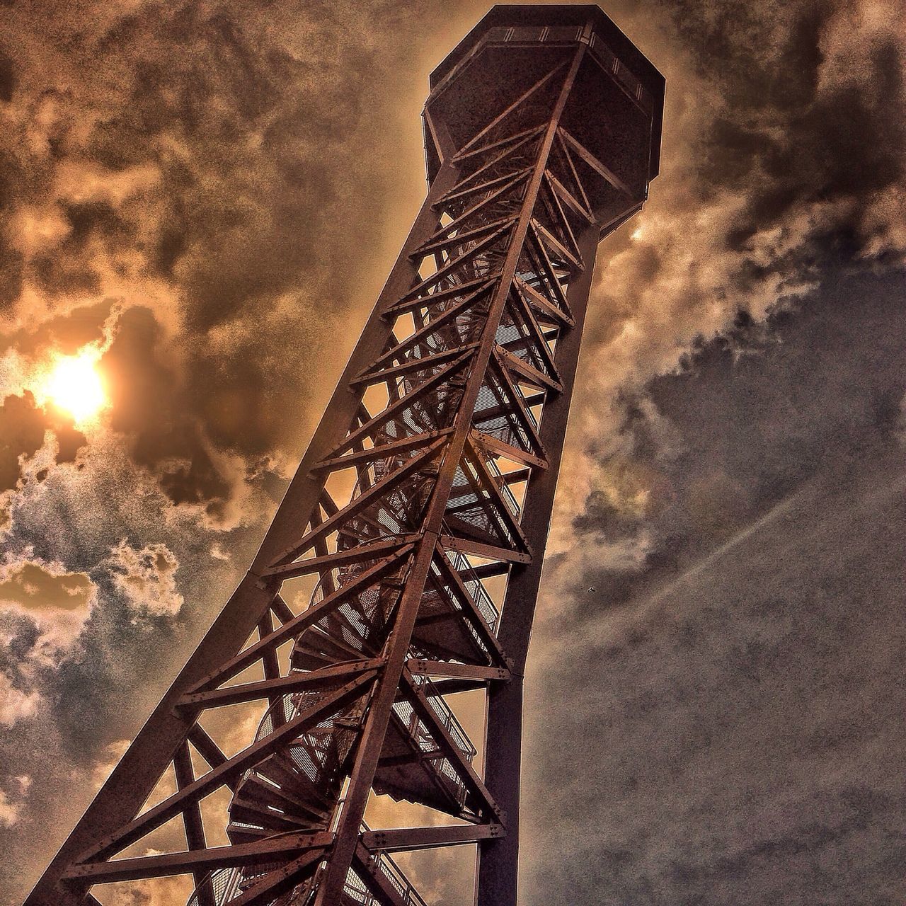 built structure, architecture, sky, low angle view, sunset, cloud - sky, metal, connection, dusk, tall - high, outdoors, tower, building exterior, no people, city, cloudy, silhouette, engineering, metallic, sunlight