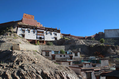 Low angle view of houses against clear blue sky